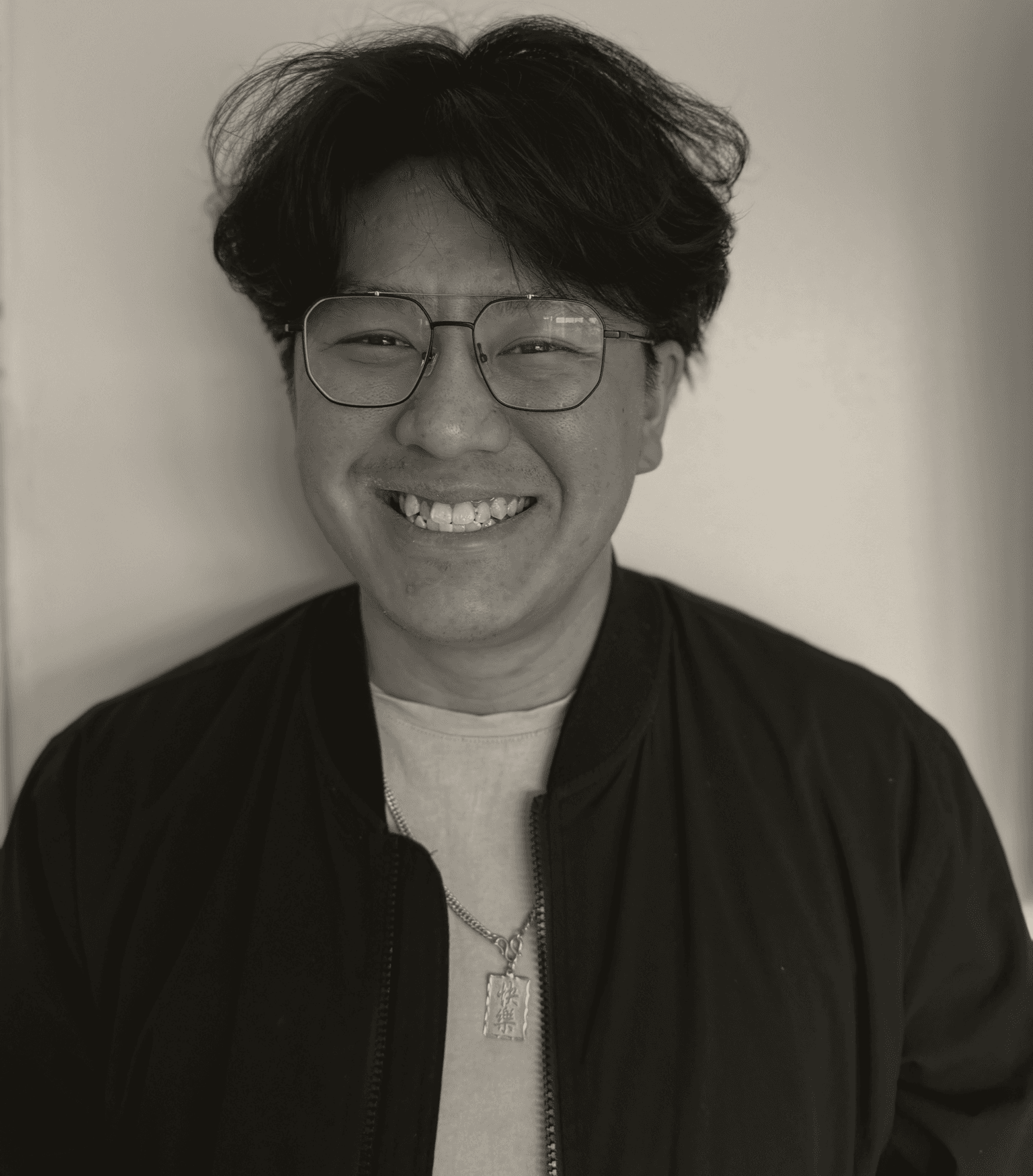 Portrait of Joey Pang wearing glasses and a black bomber jacket